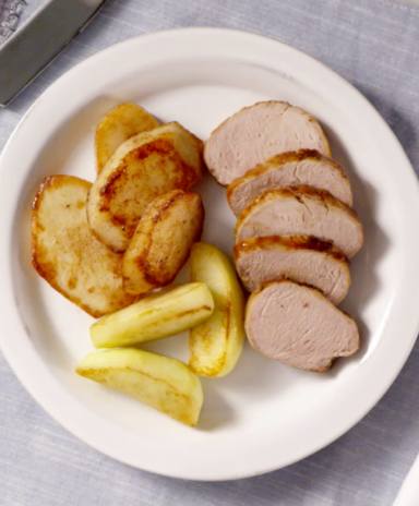 Pork, apple, and potato bake dish served on a plate